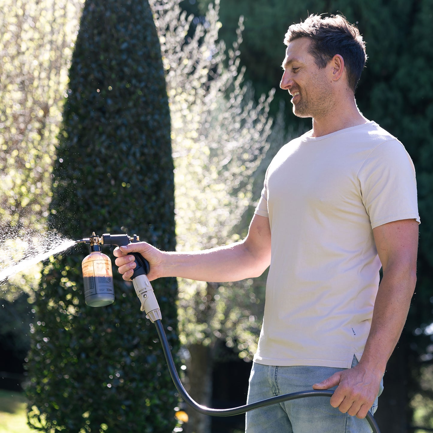 Ben Hayman using fertiliser spray mixer in backyard