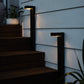 Two solar path lights on wooden steps in front of a white weatherboard house