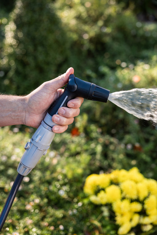 Compact Nozzle Starter Set in use with shower spray setting in garden