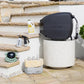 Fertiliser Spray Mixer, Sea Weed Tonic, 9-Pattern Sprinkler and Adapter Pack sitting on sandstone steps next to a white stone table with a Charcoal Evolve Retractable Hose Reel on it.