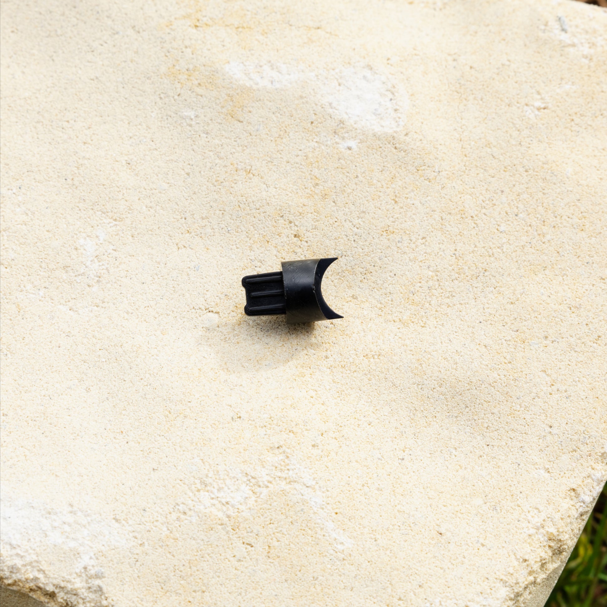 Close up of black evolve gear tooth on a sandstone paver