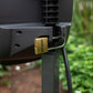 Brass Evolve Padlock securing a charcoal Evolve Retractable Hose Reel to the mounting post in a garden bed