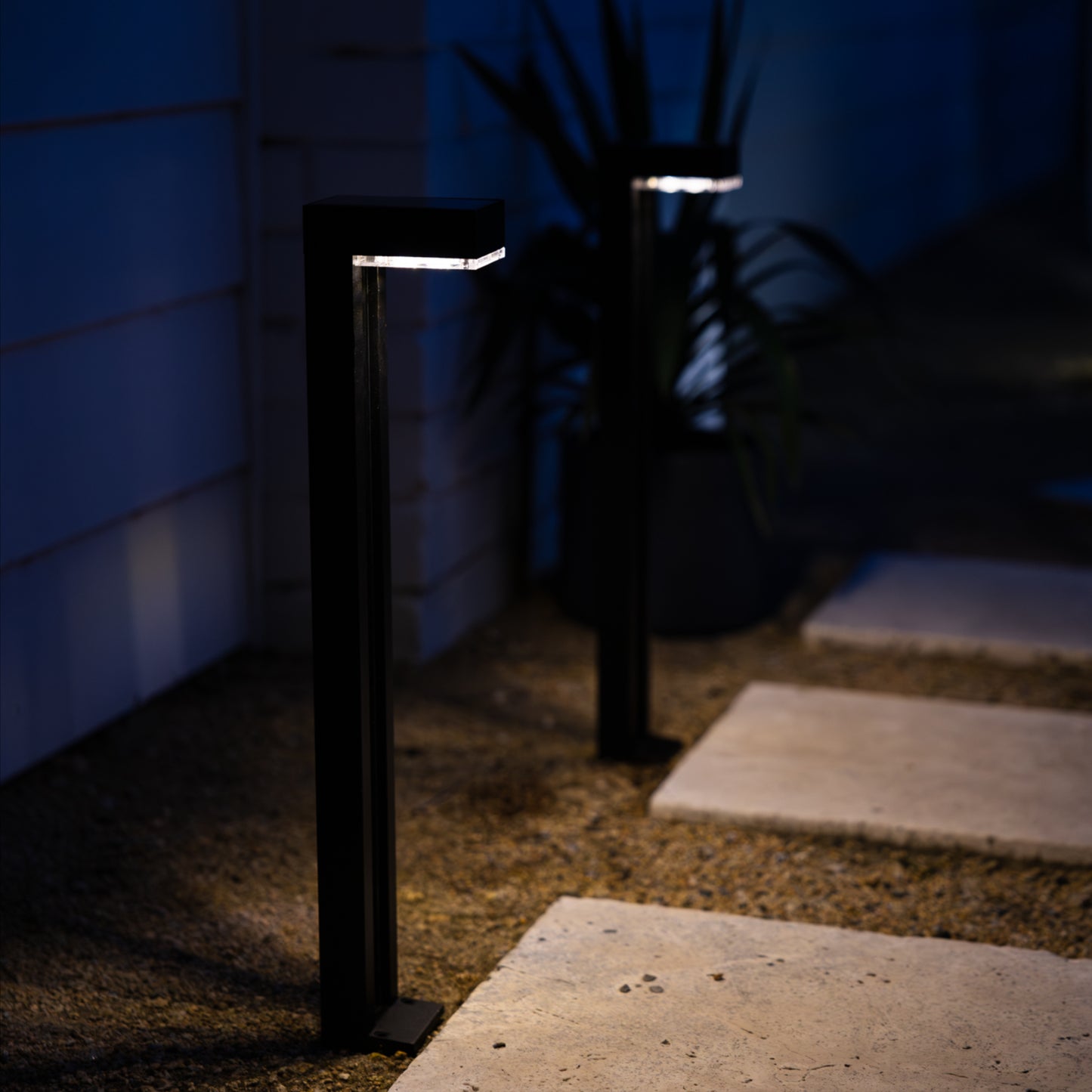 solar path lights illuminating pavers on gravel path